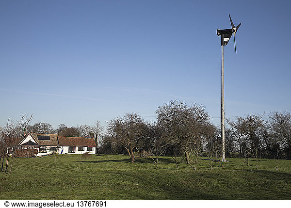 Einzelne Windturbine für die Stromerzeugung in Haushalten im Garten eines Hauses Wardspring Farm in der Nähe von Saxmundham Suffolk England