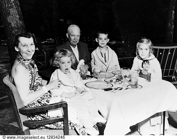 EISENHOWER FAMILY. Mamie and Dwight D. Eisenhower seated around the dinner table with their grandchildren  Susan  David and Barbara Anne. Photograph  c1955.