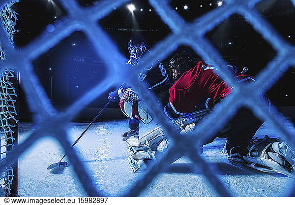 Eishockey-Torwart verteidigt Netz gegen Stürmer