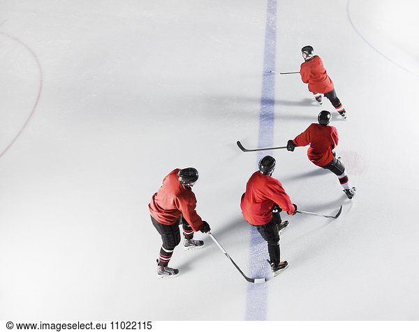 Eishockeymannschaft in roten Uniformen Schlittschuhlaufen auf dem Eis