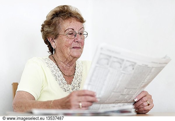 Elderly woman reading a newspaper