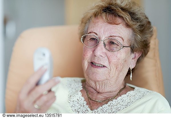 Elderly woman smiling at her mobile phone