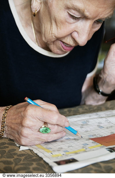 Elderly woman solving crosswords