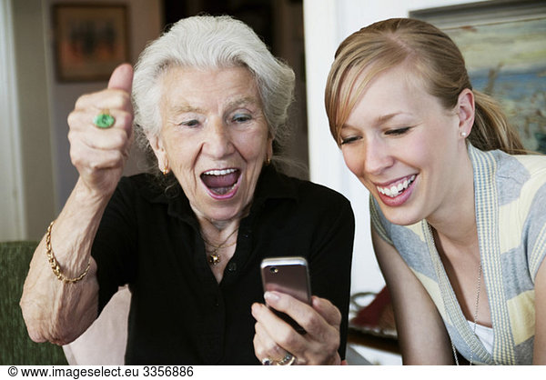 Elderly woman with cellphone beaming with joy