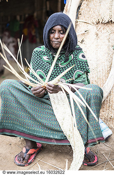 Elderly woman working with straw in Melabday village  Asso Bhole  Dallol  Danakil Depression  Afar Region  Ethiopia  Africa