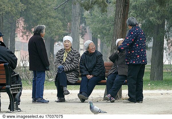 Elderly women gather to spend time in the morning mist in a park in Beijing. China. People's Republic of China.