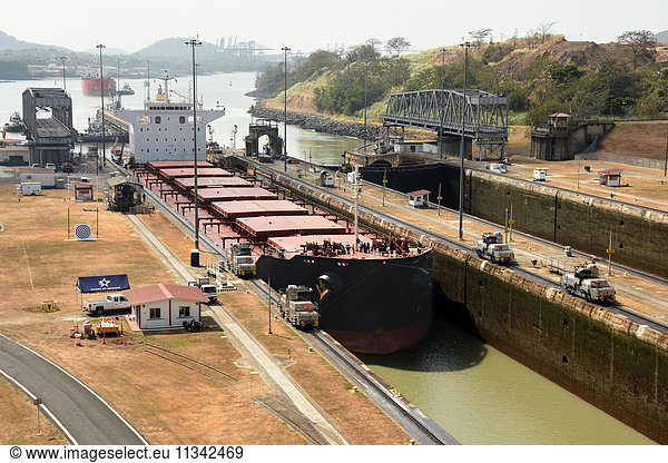 Electric mules guiding Panamax ship through Miraflores Locks on the Panama Canal  Panama  Central America