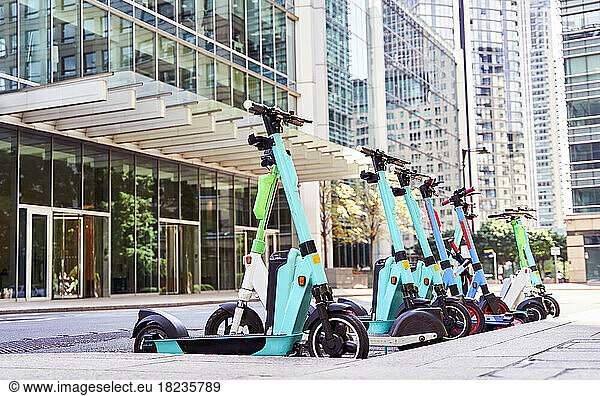 Electric push scooters parked in front of buildings