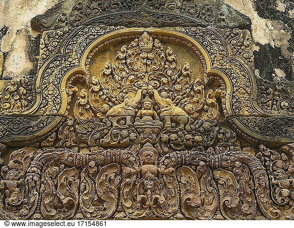 Elefanten besprengen Lakshmi mit Wasser.Banteay Srei oder Banteay Srey ist ein kambodschanischer Tempel aus dem 10. Jahrhundert  der dem Hindu-Gott Shiva gewidmet ist. Er befindet sich in der Gegend von Angkor in Kambodscha. Er liegt in der Nähe des Hügels Phnom Dei  25 km (16 Meilen) nordöstlich der Hauptgruppe von Tempeln  die einst zu den mittelalterlichen Hauptstädten von Detail gehörten. Yasodharapura und Angkor Thom. Banteay Srei ist größtenteils aus rotem Sandstein erbaut  ein Material  das sich für die kunstvollen dekorativen Wandschnitzereien eignet  die noch heute zu sehen sind. Die Gebäude selbst haben einen für angkorianische Verhältnisse ungewöhnlich kleinen Maßstab. Diese Faktoren haben den Tempel bei Touristen äußerst beliebt gemacht und dazu geführt  dass er weithin als kostbarer Edelstein oder Juwel der Khmer-Kunst gepriesen wird. '. Der am 22. April 967 n. Chr. geweihte Banteay Srei war der einzige große Tempel in Angkor  der nicht von einem Monarchen erbaut wurde. Sein Bau wird einem Höfling namens Yajnavaraha / Yaj?avar? ha zugeschrieben.