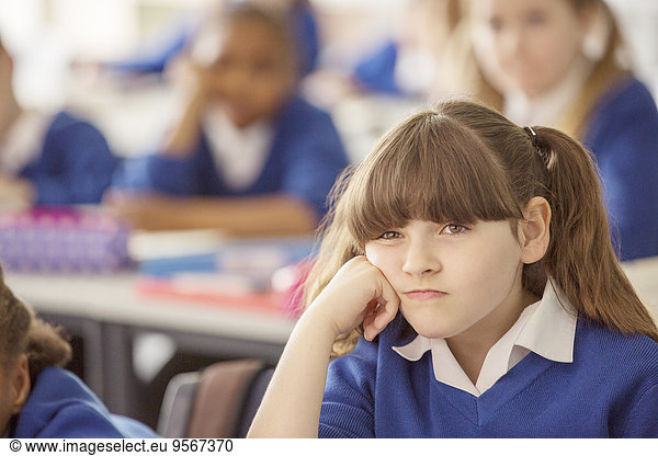 Elementary schoolgirl looking bored during lesson