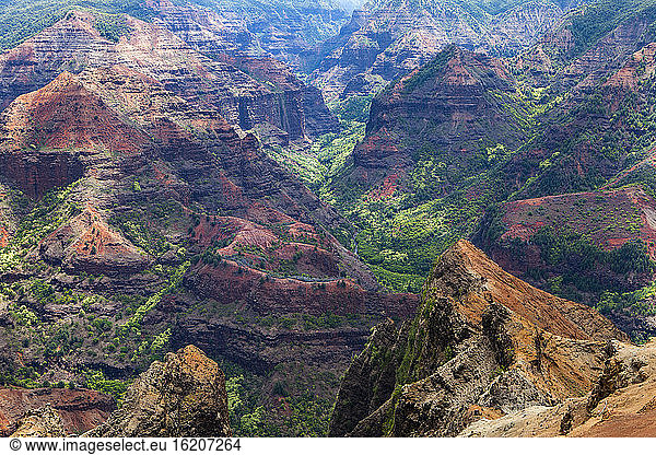Elevated view of deep canyons  green fertile valleys and steep peaks of an island landscape