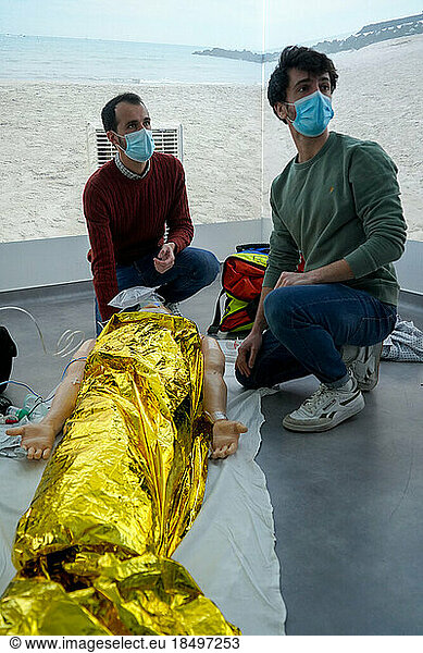 Emergency medicine students attends a circumstantial emergency simulation course led by two emergency physicians. Simulation of a drowning case at the beach. Realistic images and sound are projected all around the room to immerse students in total immersion. A young girl came up to the water's edge in cardiac arrest.