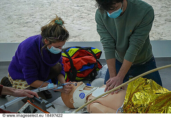 Emergency medicine students attends a circumstantial emergency simulation course led by two emergency physicians. Simulation of a drowning case at the beach. Realistic images and sound are projected all around the room to immerse students in total immersion. A young girl came up to the water's edge in cardiac arrest. Cardiac massage and intubation are performed on site.