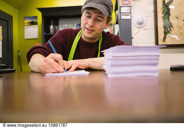 Employee in general store writing notes in office