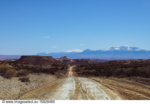 Empty back dirt roads in Utah with mountains in distance