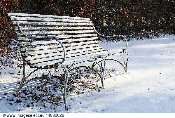 Empty bench on snowy ground