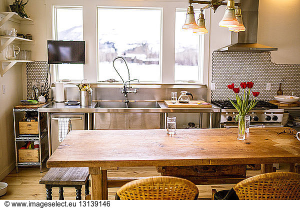 Empty chairs at table by kitchen counter at home