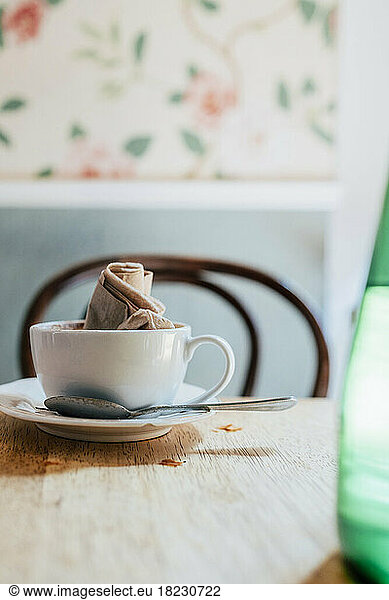 Empty coffee cup with crumpled napkin on table