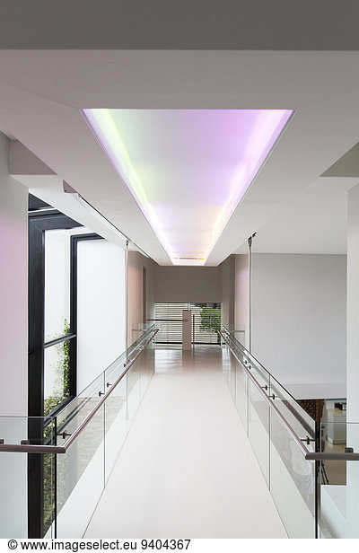Empty corridor in modern building with colored lighting above