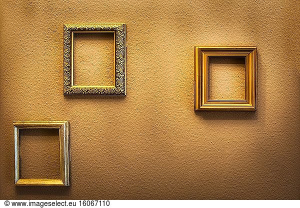 Empty golden luxury frames on vintage design wall  space for text. antique luxe interior background.