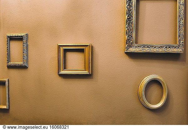 Empty golden luxury frames on vintage design wall  space for text. antique luxe interior background.