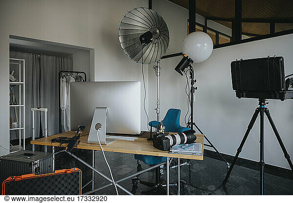 Empty studio with photography equipment at desk