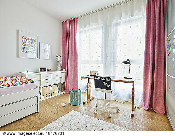 Empty study room with pink curtains in apartment