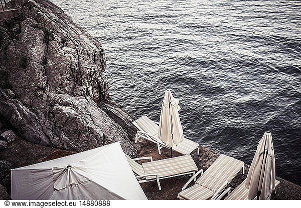 Empty sun loungers on rocky coast  high angle view  Lovran  Primorsko-Goranska  Croatia