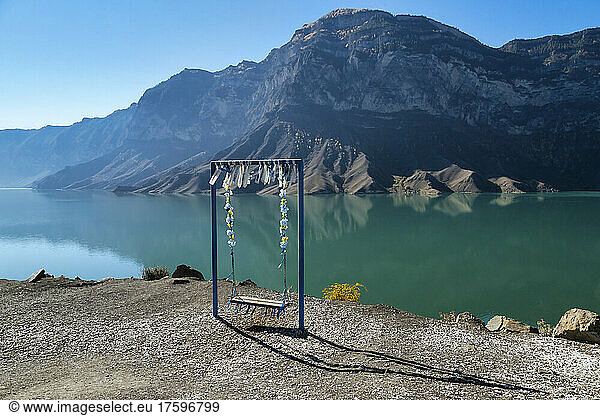 Empty swing overlooking mountain lake