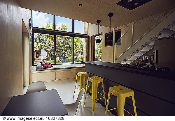 Empty yellow stools by kitchen counter in tiny house