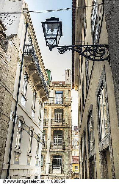 Enge  von Gebäuden gesäumte Straße; Lissabon  Portugal'.
