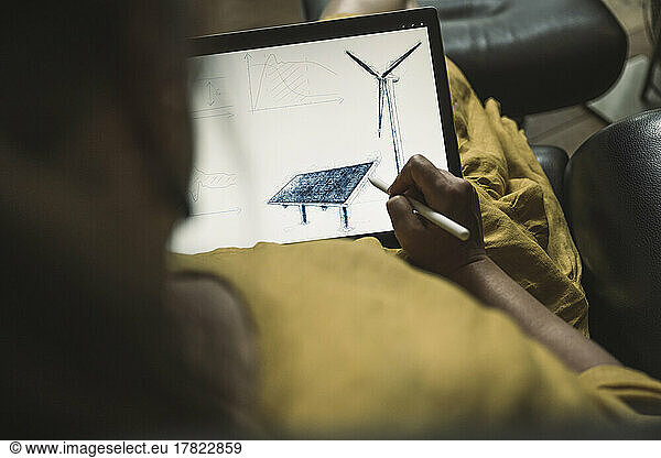 Engineer designing solar panel on graphics tablet at home office