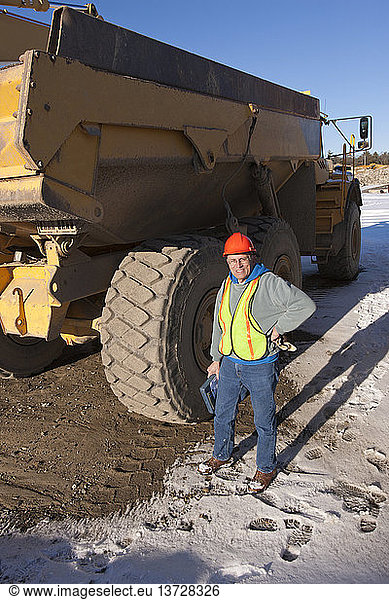 Engineer during inspection of earth movers at a construction site