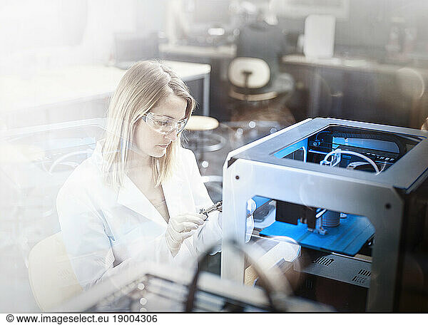 Engineer examining 3d printer in laboratory