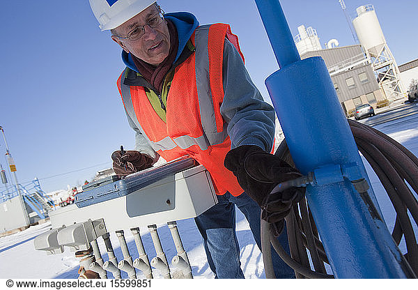 Engineer examining pneumatic hoses at industrial facility