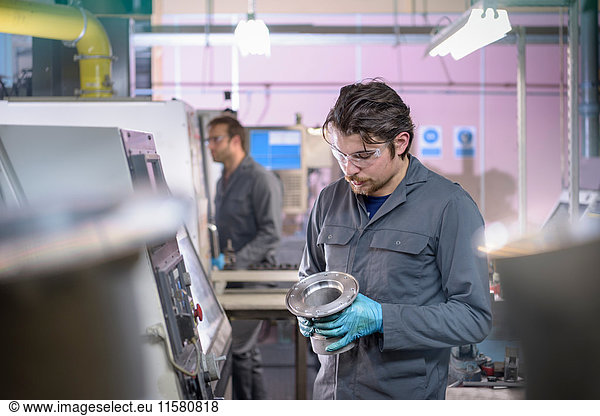 Engineer finishing aluminium component in precision casting factory