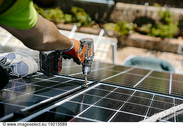 Engineer installing solar panel with drill machine