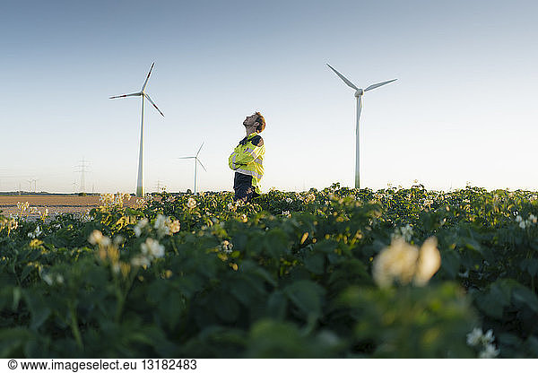 Engineer standing in a field at a wind farm