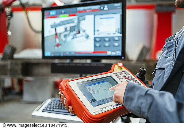 Engineer touching screen of controller in industry