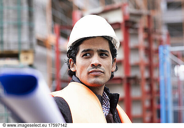 Engineer wearing hardhat and reflective vest outdoors