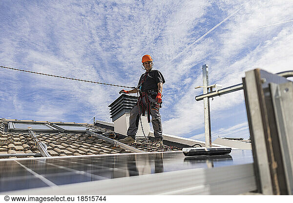 Engineer wearing safety harness standing on rooftop