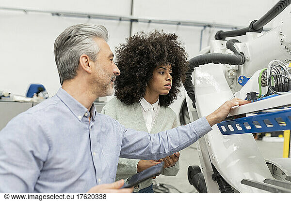 Engineers examining machinery in factory