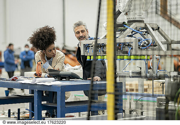 Engineers examining machinery in factory