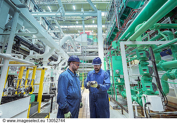 Engineers in turbine hall in nuclear power station