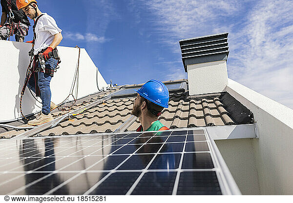 Engineers installing solar panel on rooftop