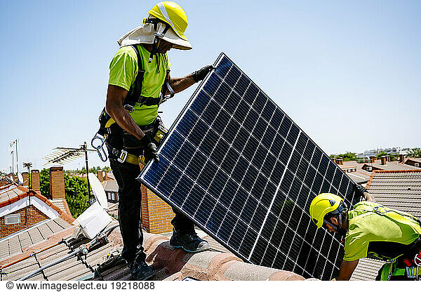 Engineers installing solar panel on sunny day
