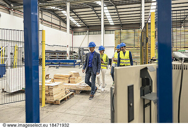 Engineers wearing hardhats walking in factory