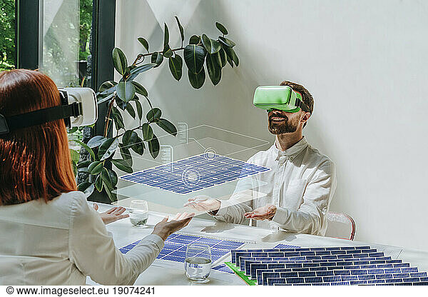 Engineers wearing virtual reality simulators designing and working on solar panels