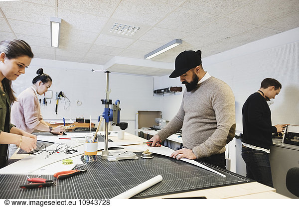 Engineers working on desk at workshop in creative office