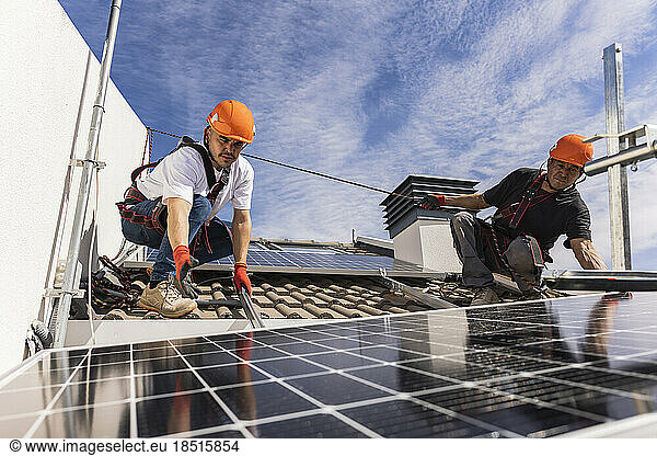 Engineers working with solar panels on rooftop